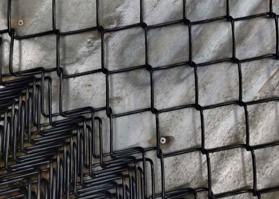 ポリ塩化ビニールは黒い電流を通されたチェーン・リンクの塀のダイヤモンドに形づける金網のスポーツ界を塗った